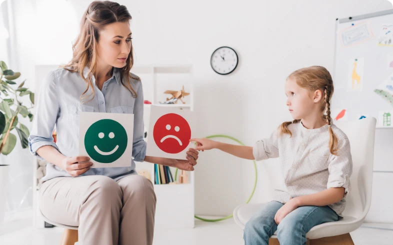 Teacher showing emotion cards to child